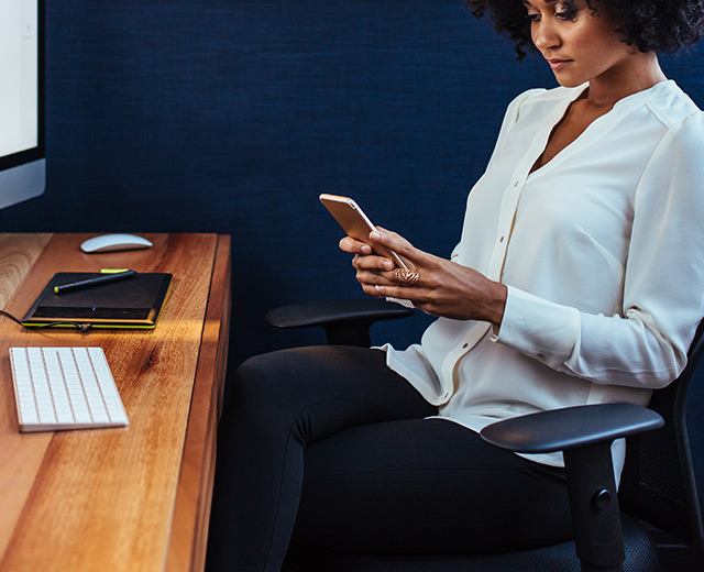 Business women texting and communicating through her mobile phone using the in-building or indoor wireless coverage
